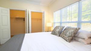 Kendal GreenSpacious Apt with Pool的卧室里有一张白色的床和一扇大窗户