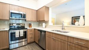 Kendal GreenSpacious Apt with Pool的厨房配有不锈钢用具和木柜