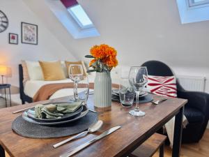 a dining room table with a vase of flowers and glasses at Ideal Studio Loft 30min to Central London in London +16 photos