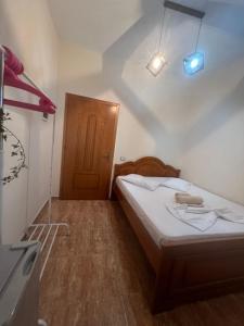 Habitación pequeña con cama y puerta de madera en Villa Andrea, en Zverneci