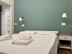 two towels sitting on top of a white bed at Appartamento Klimt in Brescia