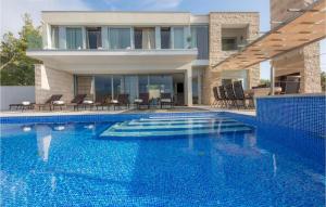 a swimming pool in front of a house at Villa Elegant in Splitska