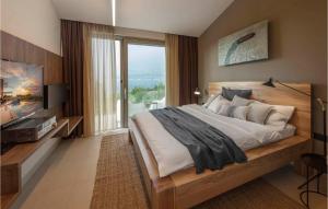 a bedroom with a large bed and a large window at Villa Elegant in Splitska