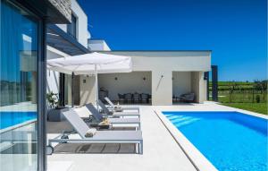 a pool with chairs and an umbrella next to a house at Villa Sole in Brtonigla +38 photos