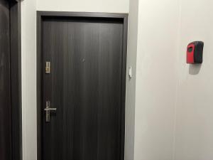 eine Holztür in einem Flur mit einem roten Alarm in der Unterkunft Przy Parku Róż II in Chorzów