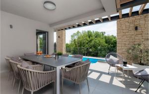 NedeščinaにあるVilla Anthea Paolaのテーブルと椅子とプールのあるパティオ