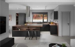NedeščinaにあるVilla Anthea Paolaの黒いキャビネット付きのキッチン、バースツール付きのキッチンアイランド
