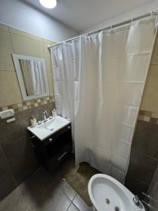 a bathroom with a white shower curtain and a sink at Departamento en Rosario centro 1 in Rosario +4 photos