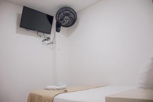 a room with a bed with a tv and a fan at Hotel Omaga El peñol- Guatape in El Peñol