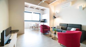 uma sala de estar com um sofá e cadeiras vermelhas em Barcelona InLoft em Barcelona