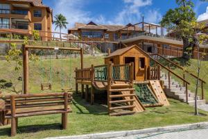 a playground with a swing and a house at Flats e apartamentos Eco resort Praia dos Carneiros in Tamandaré