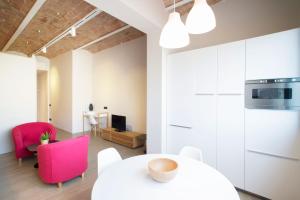 uma sala de estar com uma mesa branca e cadeiras cor-de-rosa em Barcelona InLoft em Barcelona