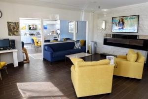 un salon avec des chaises jaunes et bleues et une table dans l'établissement Comfort Inn & Suites Coralville - Iowa City near Iowa River Landing, à Coralville