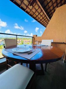 a wooden table with wine glasses on top of it at Flats e apartamentos Eco resort Praia dos Carneiros in Tamandaré