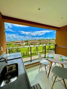 a kitchen with a large window with a table and chairs at Flats, Apartamentos e Bangalôs na Praia dos Carneiros, ao lado da Igrejinha de São Benedito in Praia dos Carneiros
