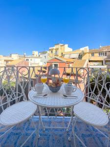 a table with two chairs and wine glasses on a balcony at Vailato Swan White Suite in Corfu