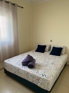 a bedroom with a bed with a purple towel on it at Appartement spacieux avec terrasse à 10 minutes du centre in Tangier