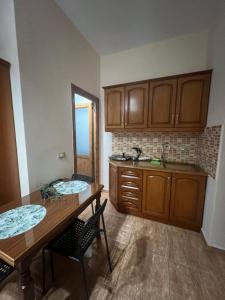 una cocina con armarios de madera y una mesa y sillas de madera. en Villa Andrea, en Zverneci 28 fotos más