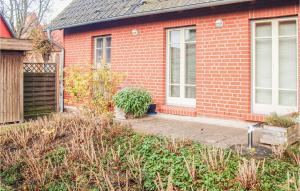 a red brick house with a patio in front of it at 2 Bedroom Amazing Apartment In Koserow in Ostseebad Koserow +11 photos