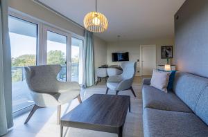 a living room with a couch and chairs at Strandlounge - 5 Sterne-Wohnung mit XXL-Balkon, Wellness & Boddenblick in Wustrow