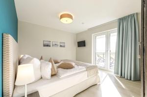 a bedroom with a bed and a large window at Strandlounge - 5 Sterne-Wohnung mit XXL-Balkon, Wellness & Boddenblick in Wustrow