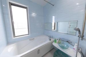 a white bathroom with a tub and a sink at Kanasha Building A - Vacation STAY 49732v in Ōkachi