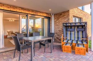 a patio with a table and chairs on a patio at MüritzKieker - Apartment in der Hafenresidenz mit Kamin & Wellness in Waren
