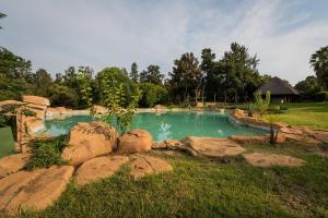 a swimming pool with rocks in a yard at Kianga Lodge & Venue in Centurion