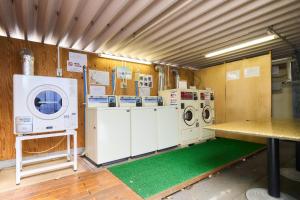 a laundry room with washing machines and a green floor at Minakuchi Century Hotel - Vacation STAY 35313v in Koka