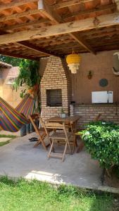 a patio with a table and hammocks under a roof at Suíte Nativa - Flecheiras in Flecheiras +15 photos