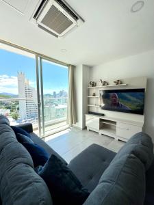 ein Wohnzimmer mit Couch und Flachbildfernseher in der Unterkunft Apartamento con hermosa vista y piscina en Santa Marta in Gaira + 24 Fotos