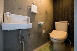 a bathroom with a toilet and a sink at ALBERGO PINO Tomari - Vacation STAY 77963v in Naha