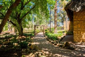 un camino en un jardín con árboles y una valla en Kianga Lodge & Venue, en Centurion