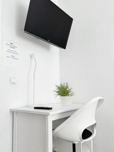a white desk with a tv on a wall at Moderne 3-Zimmer-Ferienwohnung bei Frankfurt - frisch renoviert, zentral gelegen und perfekt für Familien und Business-Trips in Egelsbach
