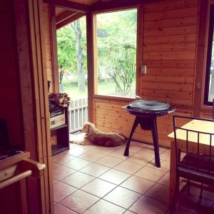 a dog laying on the floor in a room with a table at Kitakaruizawa Sweet Grass - Vacation STAY 43994v in Kita-karuizawa