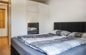 ein großes Bett mit schwarzem Kopfteil in einem Schlafzimmer in der Unterkunft Lovely Apartment In Butjadingen in Butjadingen