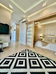 New apartments in Arcadia sea view في أوديسا: غرفة نوم بسرير وسجادة بيضاء وسوداء