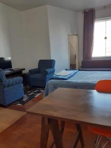 a room with a bed and two chairs and a table at Apartamento 112 Centro Consolaçao in Sao Paulo