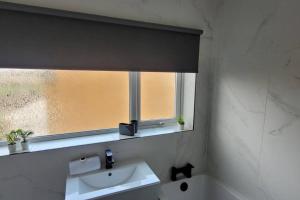 a bathroom with a sink and a window at Modern 4 Bedroom House in Lemington
