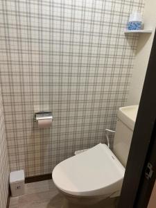 a bathroom with a white toilet and a tiled wall at Chambord Kyomachi 102,103,108,201,202,205,206,207 - Vacation STAY 19070v in Kumamoto