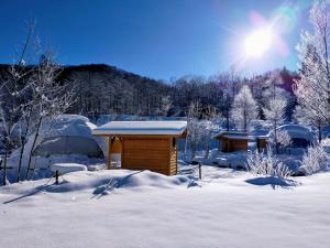 a cabin in the snow with the sun behind it at Hakuba Mori no Wasabi Farm Auto Campsite - Vacation STAY 22179v in Hakuba