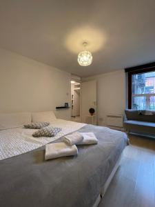 a bedroom with a large bed with towels on it at Chamberlayne Inn in London