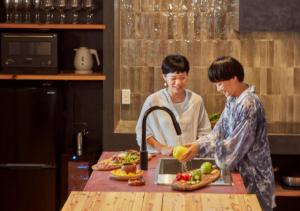 two people standing in a kitchen preparing food at Villa Oloo - Vacation STAY 44072v in Karimata