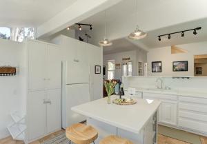 a kitchen with white cabinets and a white counter top at 3943 Rad Beach House home in Pacific Grove +33 photos