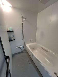 a white bathroom with a tub and a shower at HOJO Brewing & Stays - Vacation STAY 17946 in Matsuyama