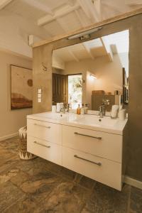 a bathroom with a sink and a large mirror at La Villa Hibiscus, Saint Martin in Cul de Sac