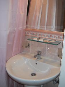 a sink in a bathroom with a pink shower curtain at Villa Ianthia in Galaxidi