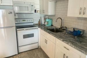 a kitchen with a white refrigerator and a sink at Landmark Towers 1705 in Clearwater Beach