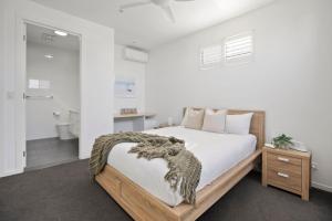 a bedroom with a bed and a bathroom at Frangipani Beach House in Kingscliff +25 photos