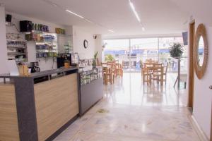 a restaurant with a counter and tables and chairs at Hotel Omaga El peñol- Guatape in El Peñol